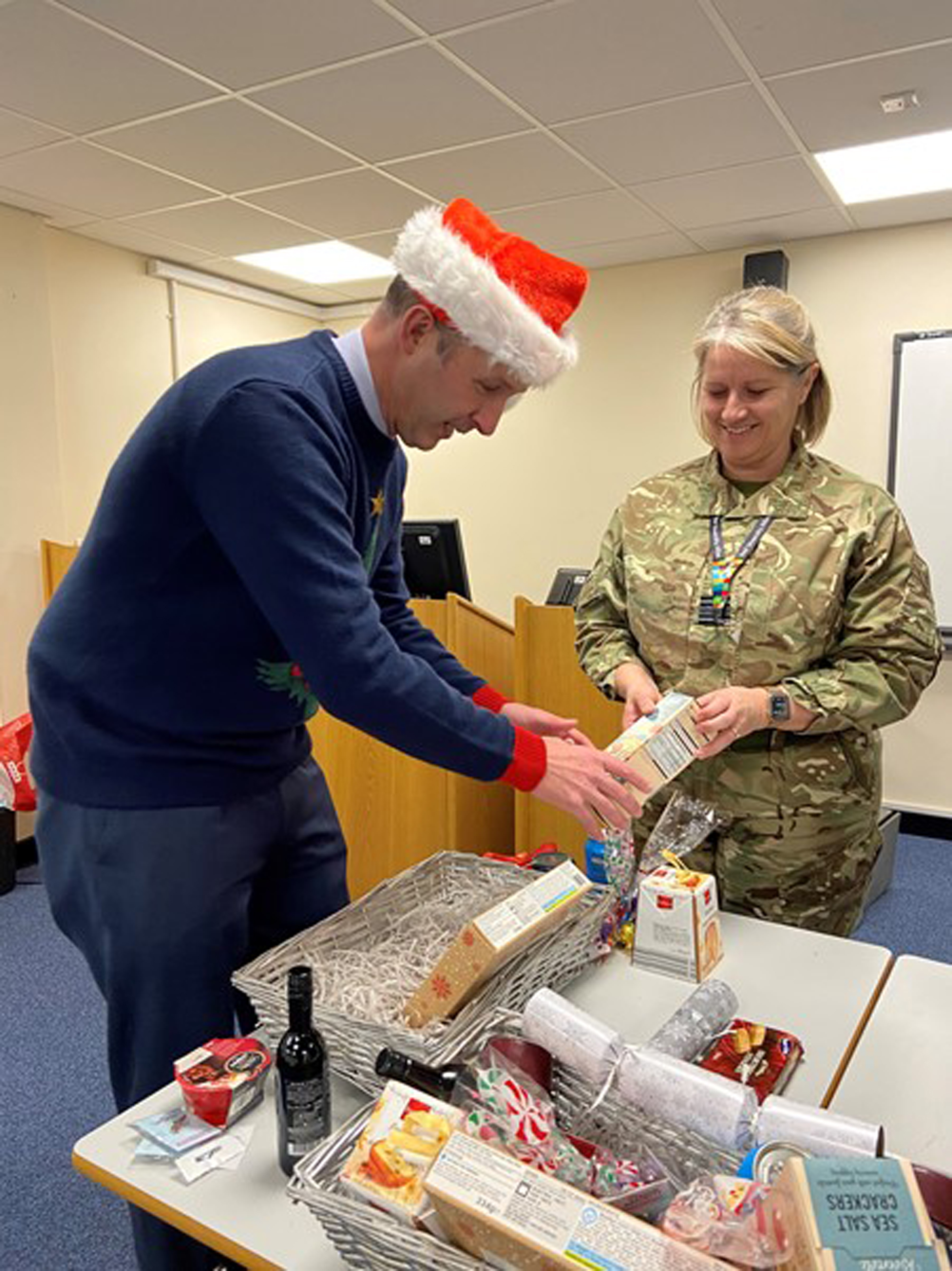 RAF Wittering Station Commander Wg Cdr Jez Case and OC 3MCS & RAFA Wittering & District Branch Chair Sqn Ldr Sara Jones help with the Christmas hampers